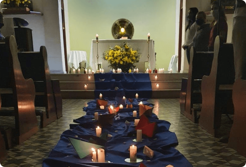 Igreja com barcos de papel e velas indo ao altar